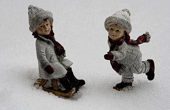 Vintage ceramic figurines of children playing in snow