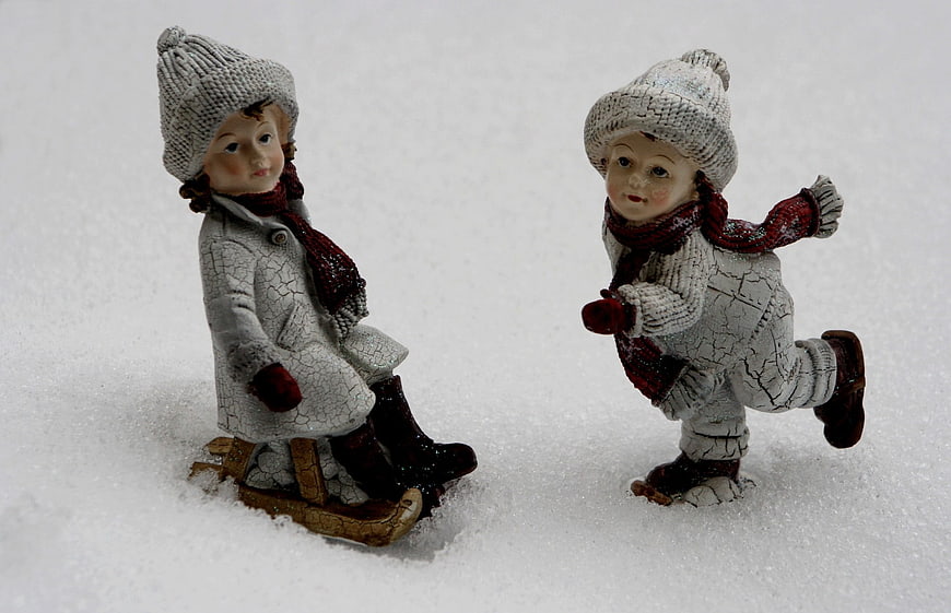 Vintage ceramic figurines of children playing in snow