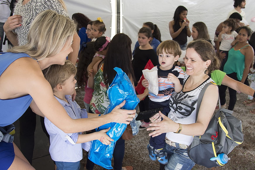 Volunteers handing gifts to children at charity event