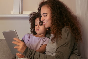 Mother and daughter using tablet together at home