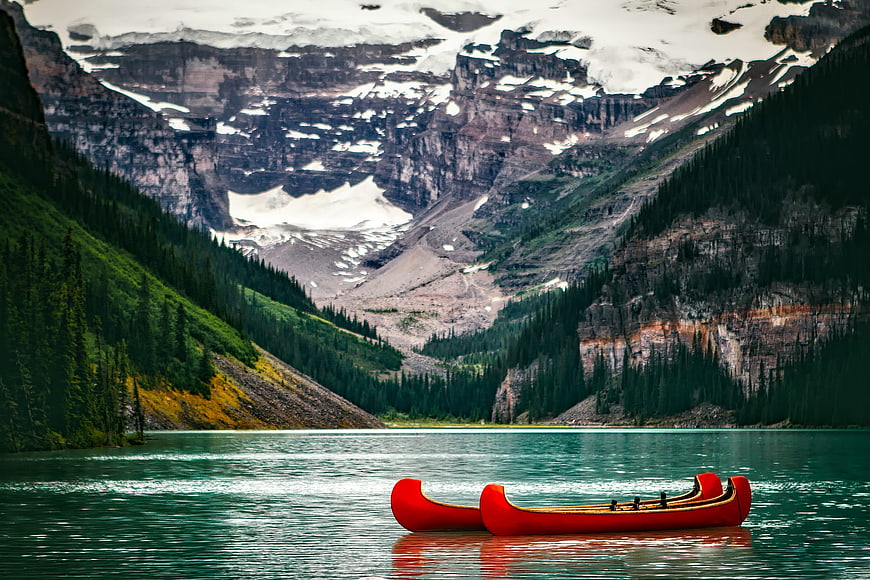 Red Canoes on Turquoise Lake with Snowy Mountains