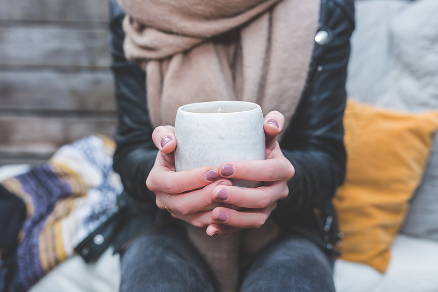 Woman Holding Warm Coffee Mug in Scarf