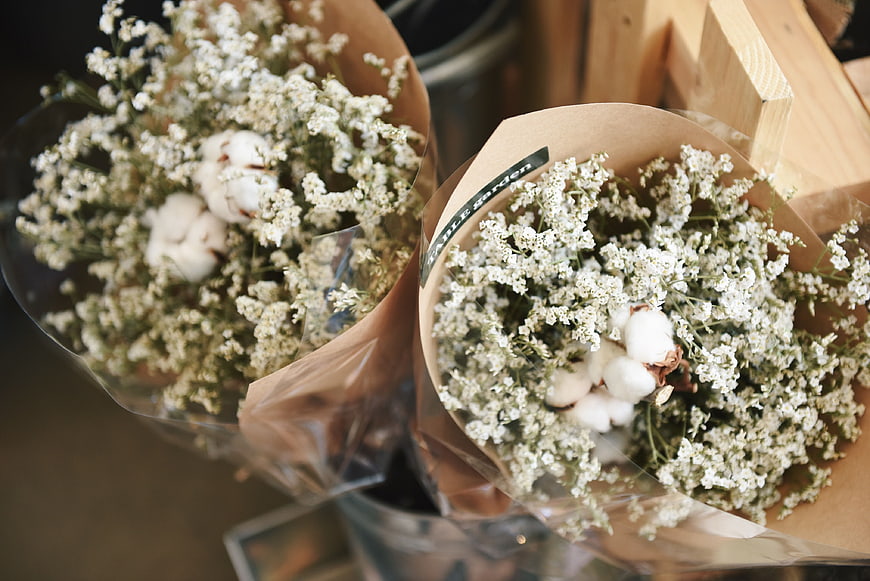 Two bouquets of baby's breath and cotton wrapped in brown paper