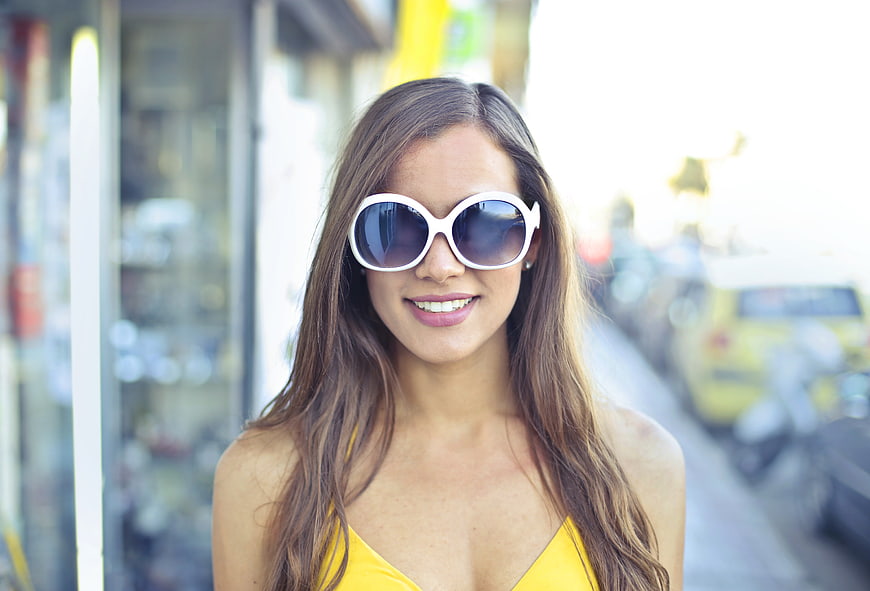 Smiling Woman in Yellow Dress and White Sunglasses on Street