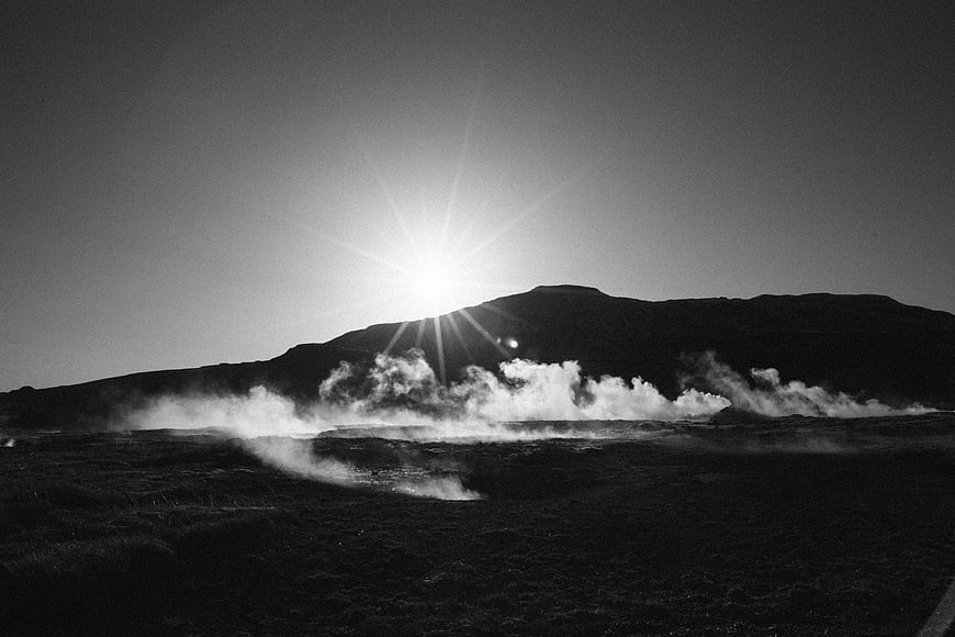 Black and white mountain silhouette with geothermal steam