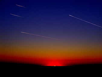 Aircraft Contrails Against Vibrant Sunset Sky Gradient