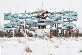Abandoned blue water slide complex in snowy winter landscape