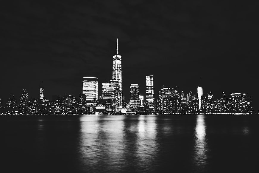 Black and White Manhattan Skyline at Night with Water Reflections