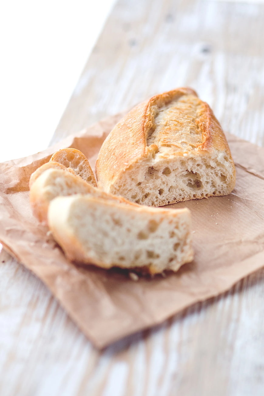 Freshly Baked Artisan Bread Slices on Brown Paper