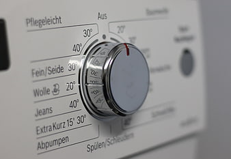 Close-up of washing machine control dial with German settings