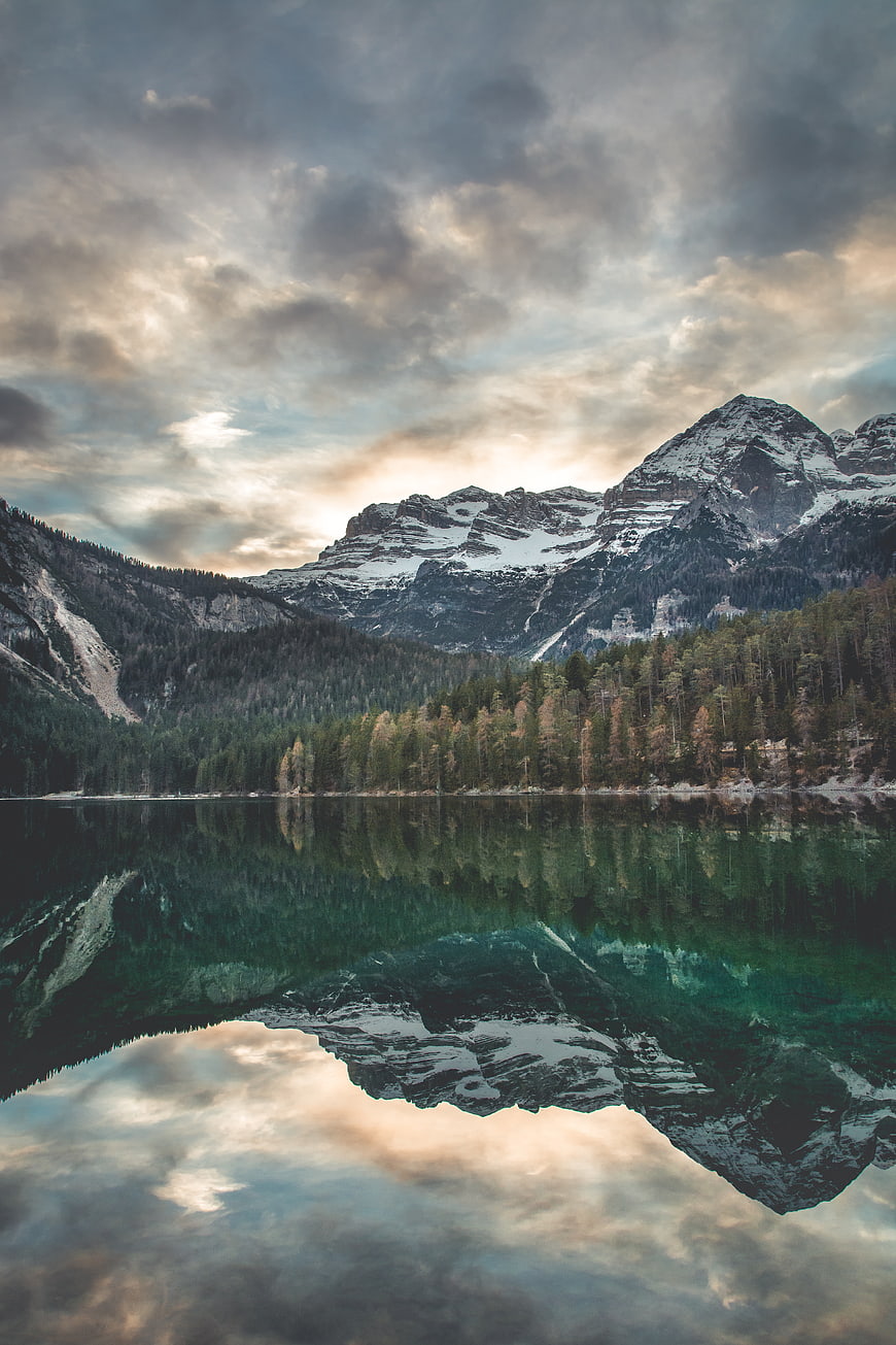 Serene Mountain Lake Reflection with Snowy Peaks and Forest