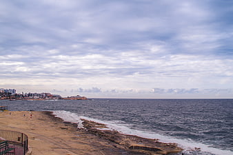 Coastal landscape with rocky shore and city skyline