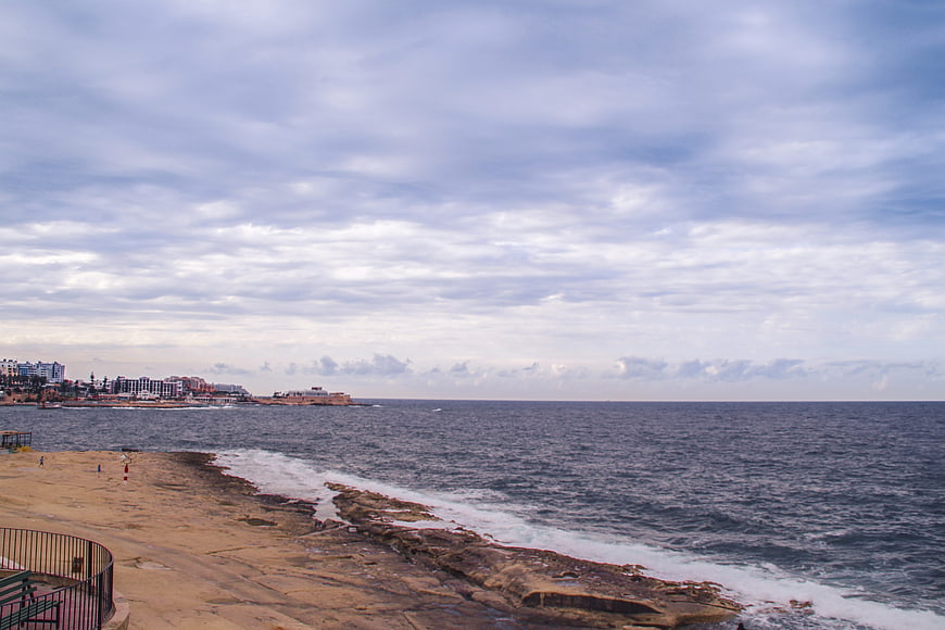 Coastal landscape with rocky shore and city skyline