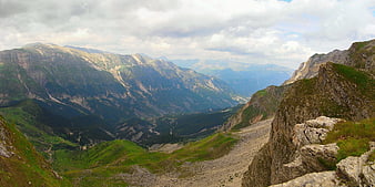 Panoramic mountain landscape with rocky peaks and green valleys