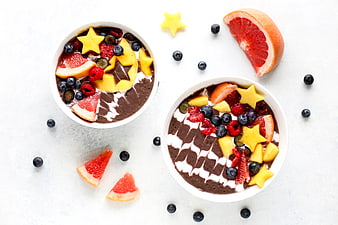 Overhead view of chocolate smoothie bowls with star-shaped fruit