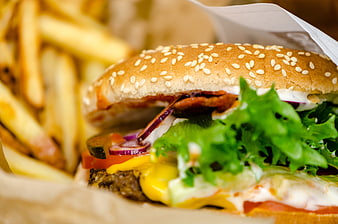Close-up of a fresh beef burger with fries and vegetables