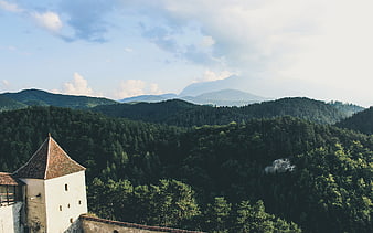 Historic Castle Tower Overlooking Lush Forested Mountains