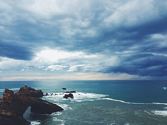 Dramatic coastal landscape with rocky cliffs and stormy ocean sky