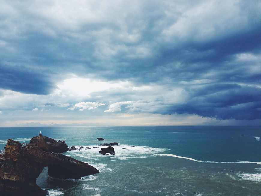 Dramatic coastal landscape with rocky cliffs and stormy ocean sky