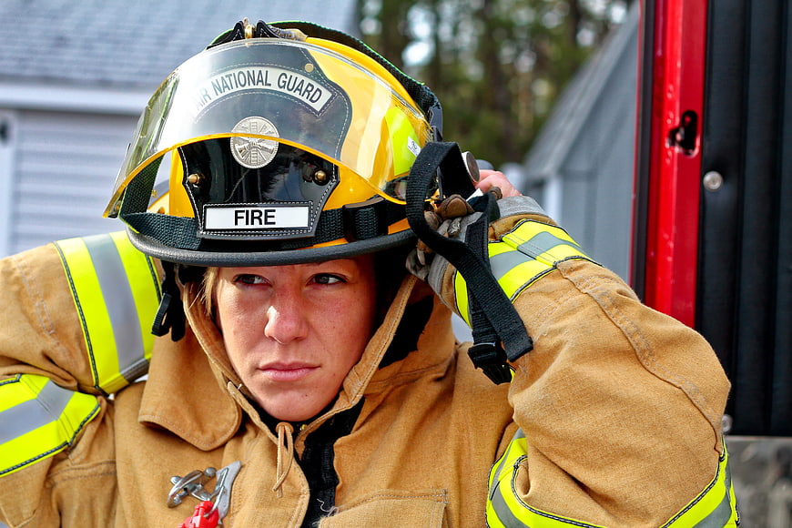 Female firefighter adjusting helmet in protective gear