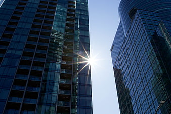 Low angle view of modern glass skyscrapers with sun flare