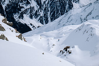 Lone skier descending a vast snowy mountain slope