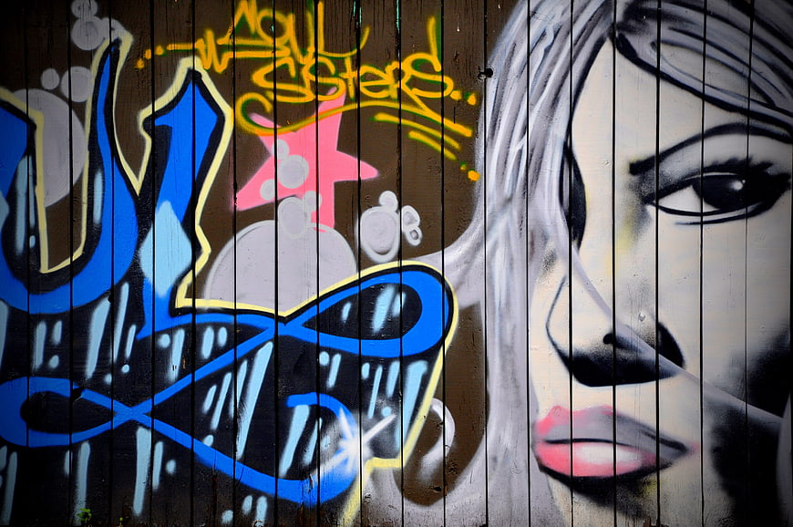 Colorful Graffiti Art on Wooden Fence with Stylized Portrait