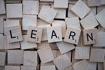 Wooden Scrabble Tiles Spelling Learn on Scattered Background