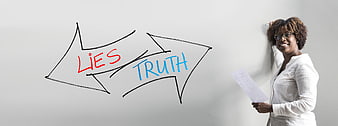 Businesswoman standing next to whiteboard with lies and truth arrows