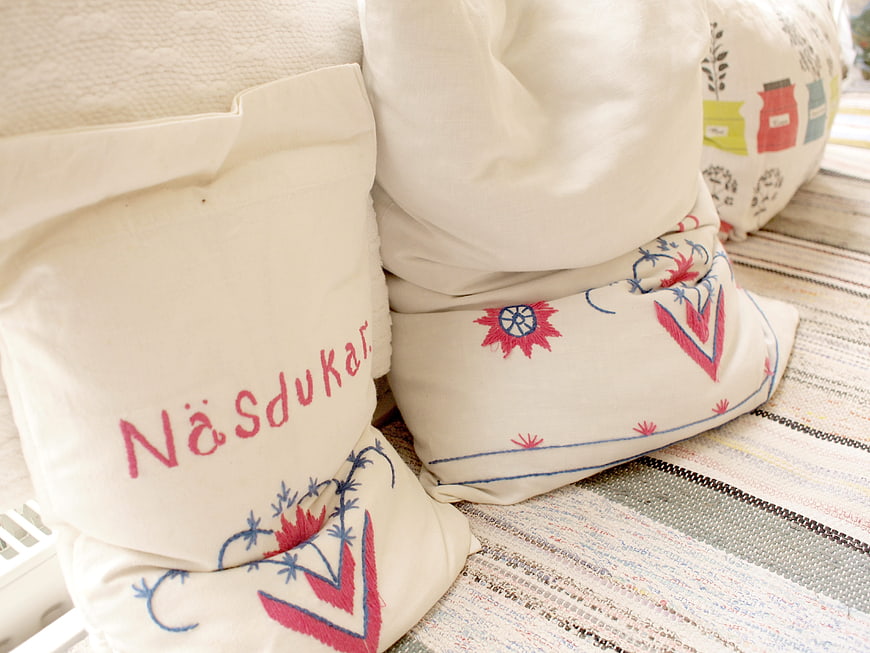 Traditional Swedish Embroidered Linen Pillows on Woven Rug