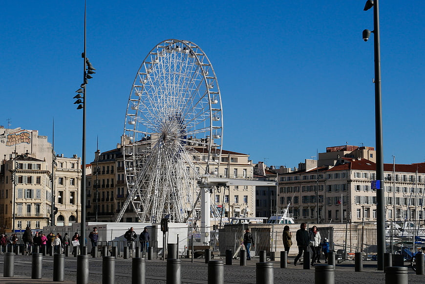 Large white Ferris wheel in Marseille port with blue sky