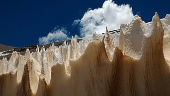 Sharp ice seracs on a glacier against a blue sky
