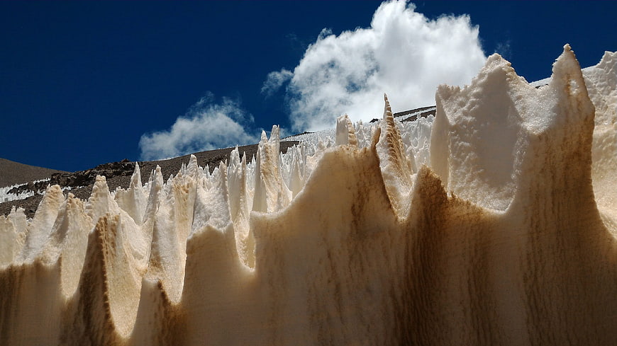 Sharp ice seracs on a glacier against a blue sky