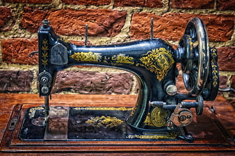 Vintage Singer Sewing Machine With Gold Ornamentation On Wooden Table
