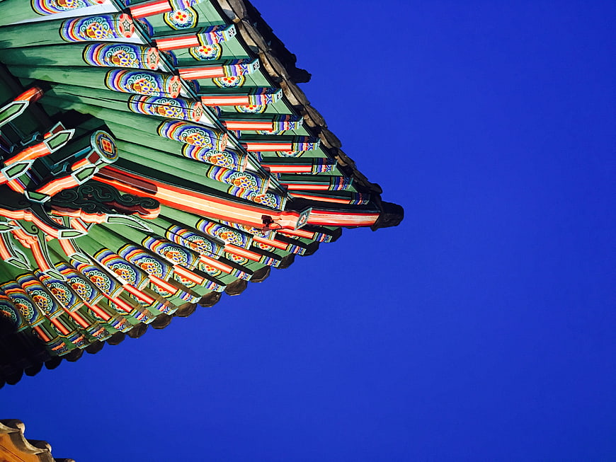 Traditional Korean Palace Roof Detail Against Deep Blue Sky