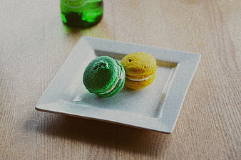 Green and yellow macarons on a white square plate