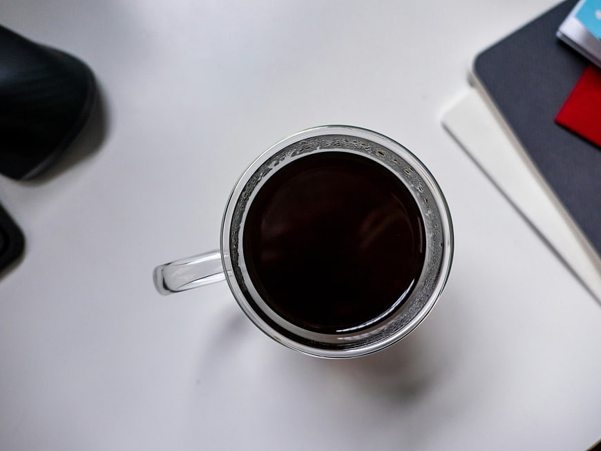 Top View of Black Coffee Cup on White Office Desk