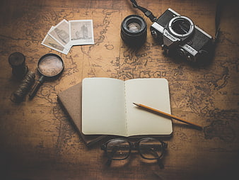 Vintage travel planning setup with camera, map, and notebook