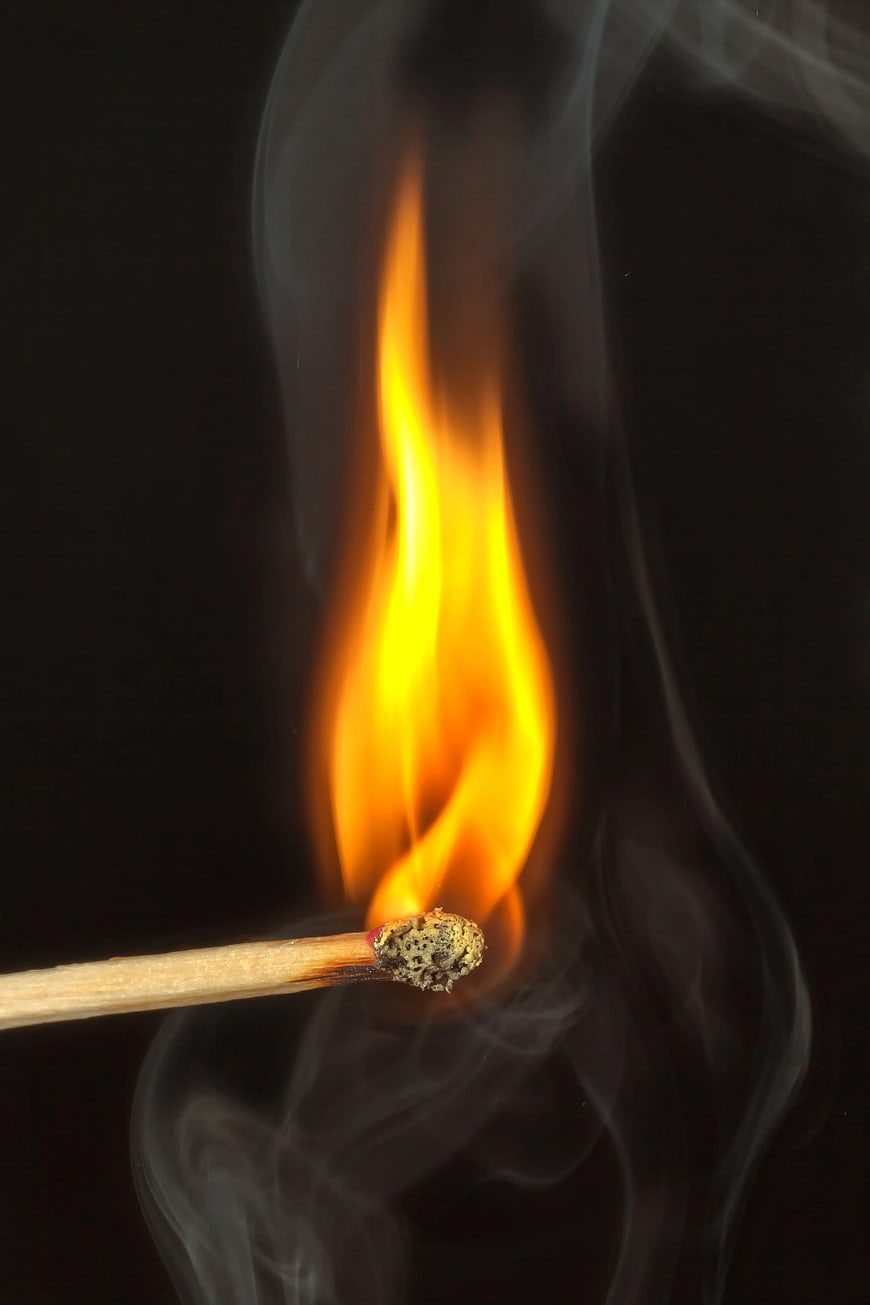 Burning Matchstick with Flame and Smoke on Black Background