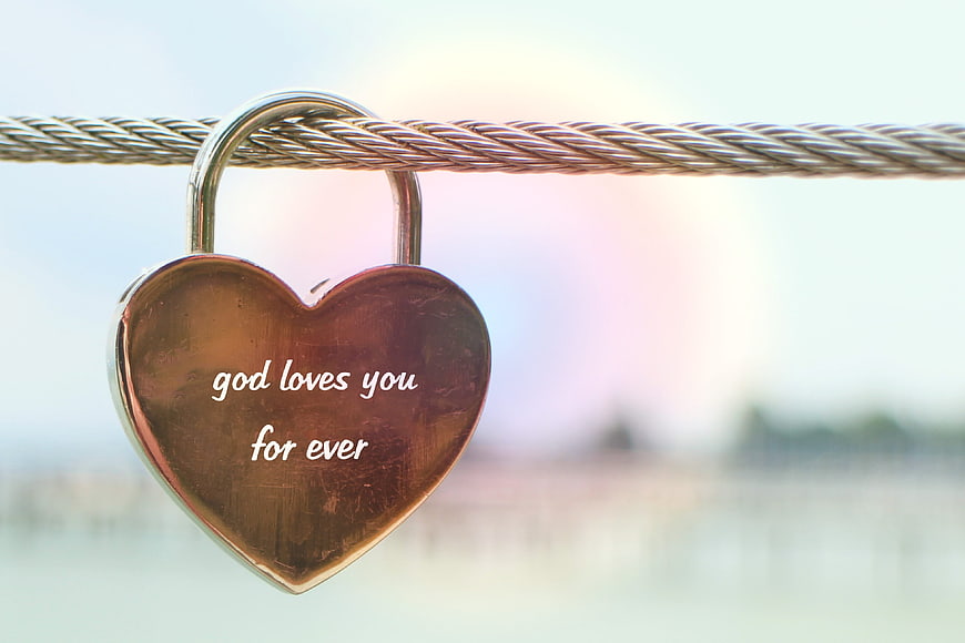 Heart-shaped padlock with 'god loves you for ever' inscription on cable