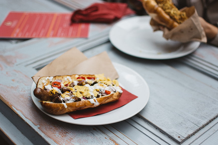 Loaded Beef Hot Dog on Rustic Wooden Table