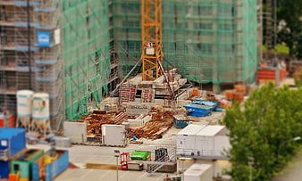 Tilt-shift construction site with tower crane and scaffolding