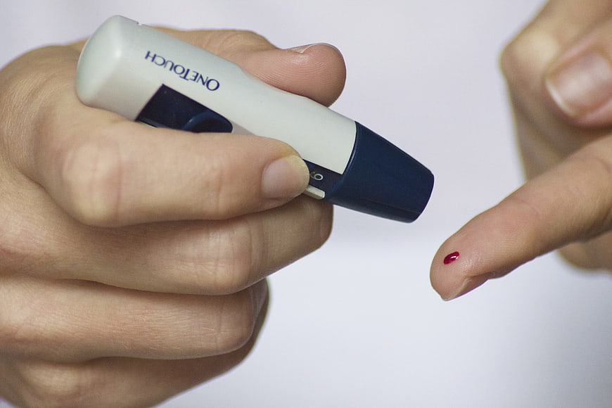 Close-up of OneTouch glucose meter and finger with blood drop