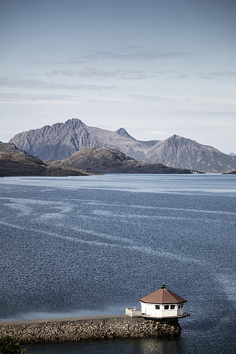 Serene Norwegian Fjord with Lighthouse and Mountains