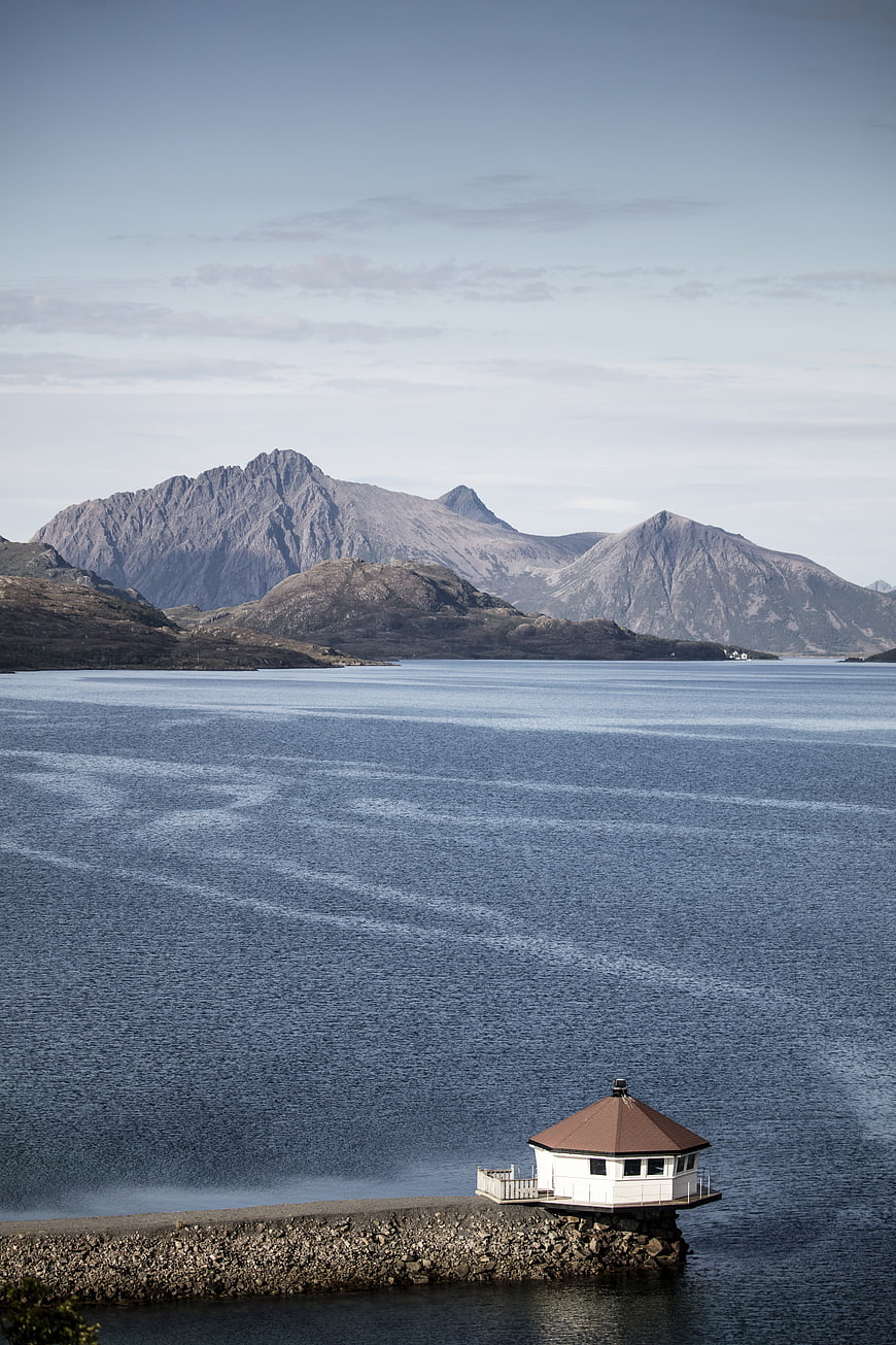 Serene Norwegian Fjord with Lighthouse and Mountains