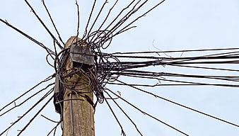 Chaotic Tangle of Wires on Wooden Utility Pole