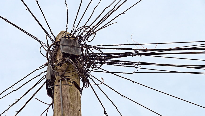 Chaotic Tangle of Wires on Wooden Utility Pole