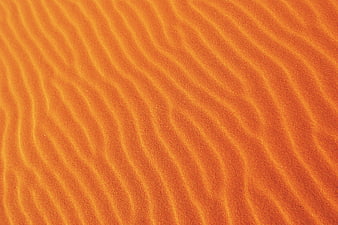 Close-up of rippled orange sand texture pattern
