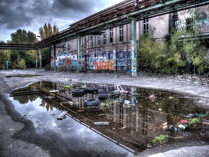 Abandoned industrial building with graffiti and puddle reflection