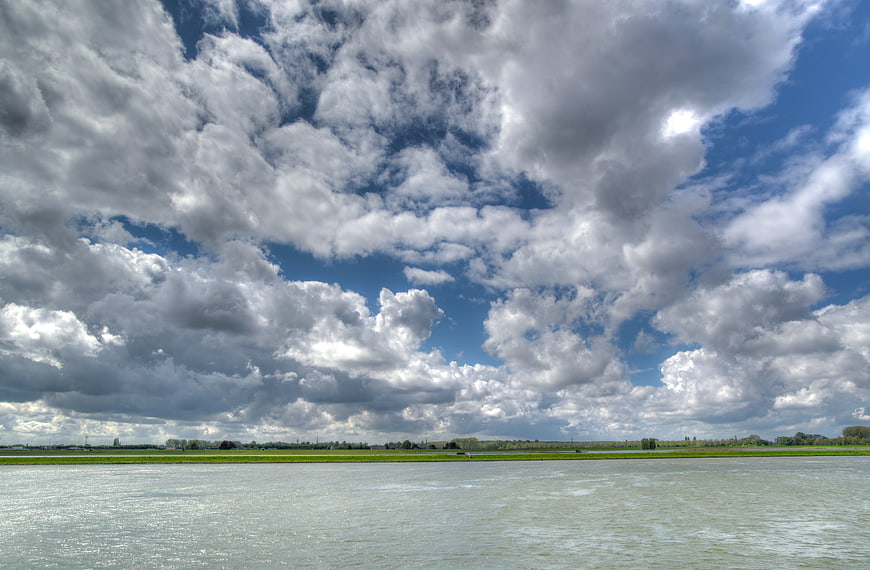 Wide river landscape with dramatic cloudy blue sky